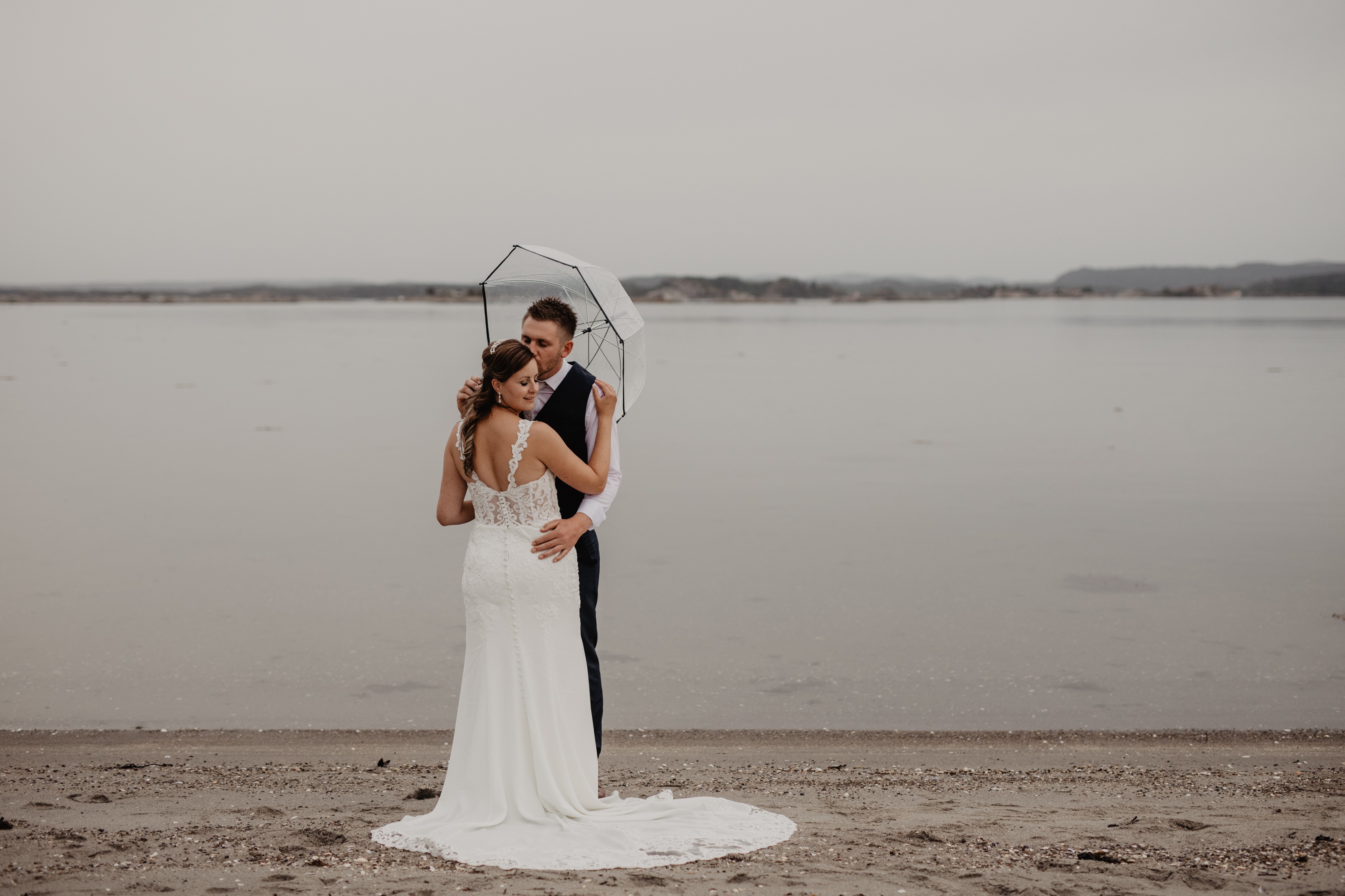 Bryllupsbilde ved strand regn og paraply Jomfruland