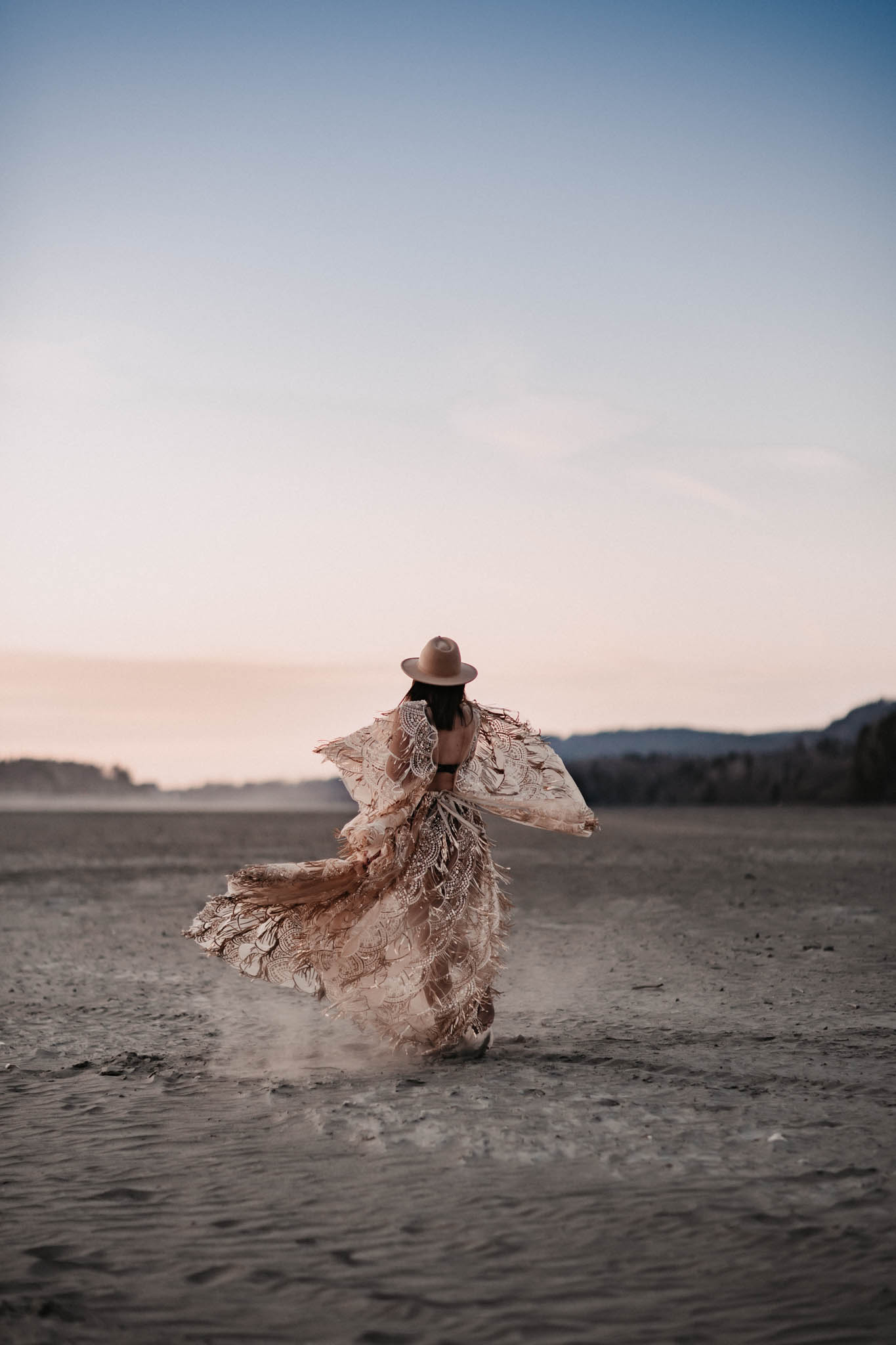 Woman in gold dress in desert sunset